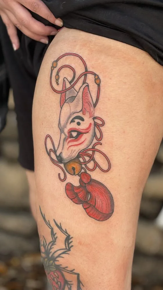 Japanese kitsune fox mask tattoo in red and white with bell and tassel
