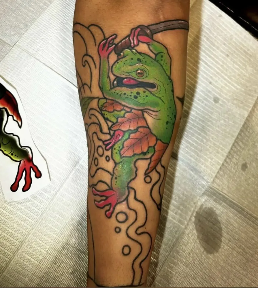 Green tree frog climbing among waves and an autumn leaf tattoo